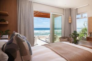 a bedroom with a bed and a view of the ocean at Secret Sands in Wilderness +71 photos