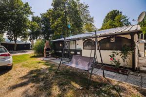 a camping trailer with a canopy in a yard at Urška's Premium House Terme Čatež in Brežice