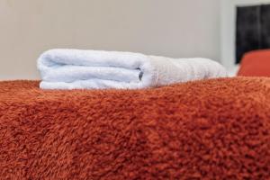 a stack of towels sitting on top of a bed at Executive 4Bedroom Sleeps 9 City Centre Nearby in Parkside +76 photos