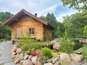 a log cabin with a pond and flowers at Fjällstugan in Sund