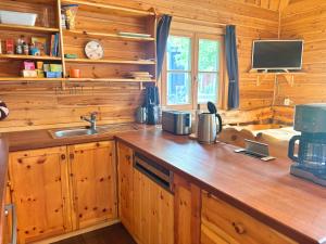 a kitchen with wooden cabinets and a counter with a sink at Fjällstugan in Sund