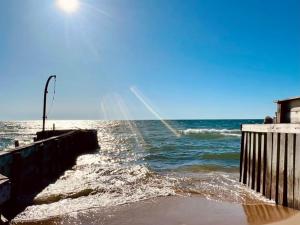 a body of water with a pier and the ocean at The SeveraLena, your Tawas Point destination! in East Tawas +49 photos