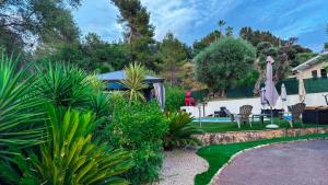 a garden with a swimming pool and a house at Villa Caraïbes in Vence