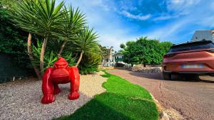 a red statue sitting on the side of a driveway at Villa Caraïbes in Vence