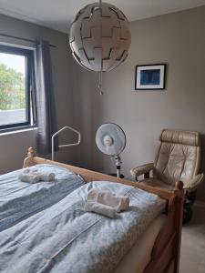 a bedroom with two beds and a lamp and a chair at Fjordhytte-24 in Bøvågen
