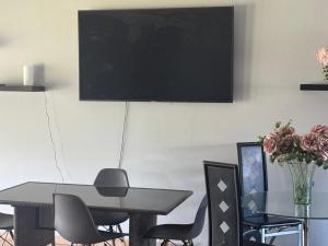 a dining room with a table and chairs and a television at Bouleigh in Kempton Park