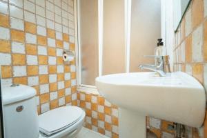 a bathroom with a white sink and a toilet at Magdalena2 Street, Private rooms in Madrid