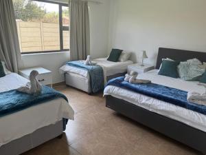 a room with three beds with stuffed animals on them at Bouleigh in Kempton Park