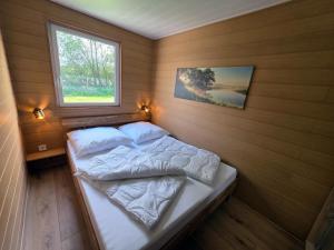 a small bedroom with a bed with a window at Bungalow Seedorf 9 in Basedow