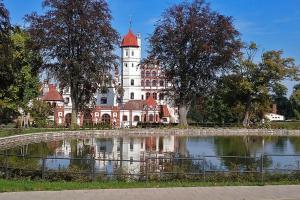 a large building with a pond in front of it at Bungalow Seedorf 9 in Basedow +5 photos