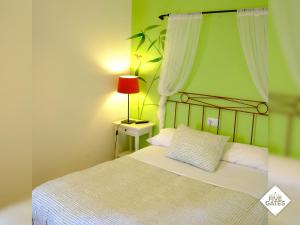 a bedroom with a bed with a red lamp on a table at Hostal Five Gates in Osuna