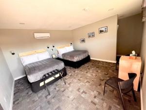 a hotel room with two beds and a chair at Skyliner Motel in Stroud +2 photos