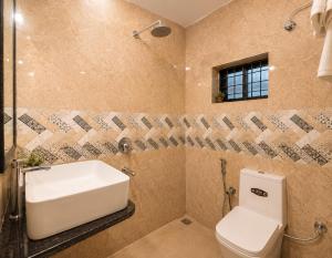 a bathroom with a white sink and a toilet at Coutinho Guest House in Panaji