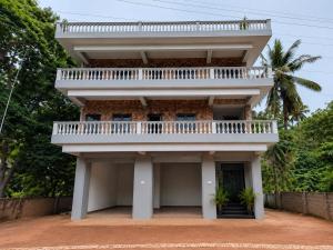 a building with a balcony on top of it at Coutinho Guest House in Panaji