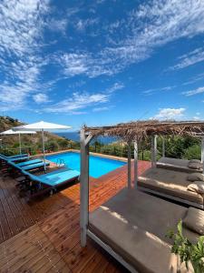a wooden deck with a swimming pool and a roof at Grand Seaview Apartments in Ksamil