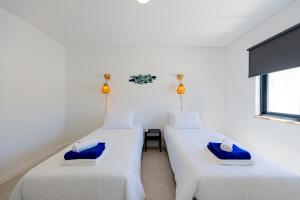 two beds in a room with white walls at Vivenda Vilhegas in Albufeira +85 photos