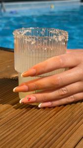 a hand holding a plastic cup next to a persons hand at The Beach House in Vasilika +2 photos