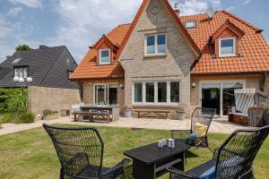 a house with a table and chairs in the yard at Sylter Inselglück in Wenningstedt