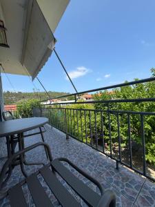 a patio with a table and chairs on a balcony at The Beach House in Vasilika