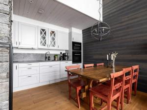 a kitchen with a wooden table and white cabinets at Spacious Slopeside Home with Sauna in Åre