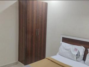 a bedroom with a wooden cabinet next to a bed at RKGRANDROOM's in Kolanukonda
