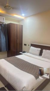 a bedroom with a large bed and a wooden cabinet at RKGRANDROOM's in Kolanukonda
