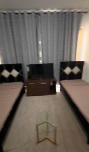 a living room with two beds and a tv at Alreem building in Abu Dhabi
