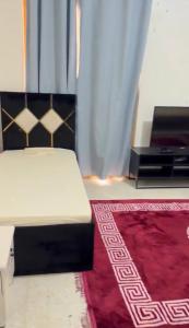 a bedroom with a bed and a red rug at Alreem building in Abu Dhabi
