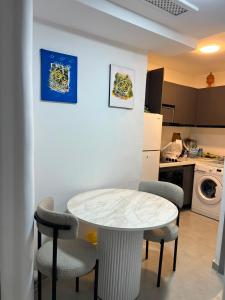 a kitchen with a table and chairs in a room at Appartement Cassia Vue Piscine rénovée cette année in Cabo Negro