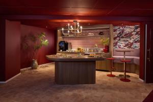 a kitchen with a counter and stools in a room at Landgoed Lauswolt in Beetsterzwaag +85 photos