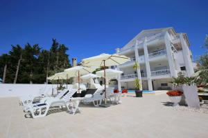een groep stoelen en parasols voor een gebouw bij Villa Triana-Adults Only in Zadar