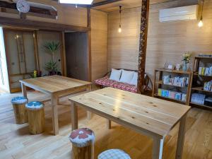 a room with two wooden tables and a bench at おかえりヒュッテ in Komagane