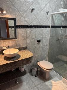 a bathroom with a toilet and a sink and a shower at Hospedaria Gãstehaus Enzian in Treze Tílias +33 photos