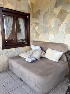 a couch sitting in a room with a stone wall at Hospedaria Gãstehaus Enzian in Treze Tílias