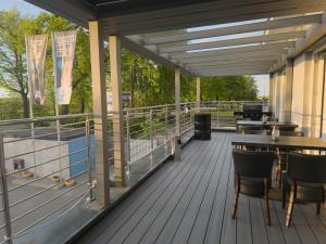 a deck of a restaurant with tables and chairs at Fairschlafen Boutique Hotel in Neustadt in Holstein
