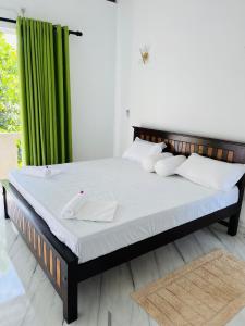a bed in a room with a green curtain at Letharo Residancies in Dodanduwa