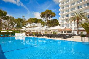 a large swimming pool in front of a hotel at Universal Hotel Castell Royal in Canyamel