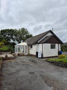 a small white house with a garage at Donrae in Portree