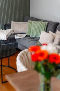 a living room with a couch and a table with flowers at App Ankerplatz in Morsum