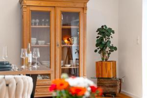 a wooden china cabinet in a room with a table at App Ankerplatz in Morsum