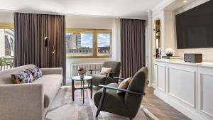 a living room with couches and chairs and a television at Bristol Berlin, Vignette Collection by IHG in Berlin