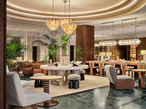 a lobby with tables and chairs and a restaurant at Bristol Berlin, Vignette Collection by IHG in Berlin