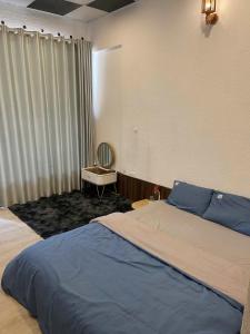 a bedroom with a bed and a desk and a window at Hoa Rừng Homestay in Xuan An