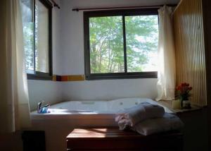 a bathroom with a bath tub and two windows at Terrazas de Lobos in Lobos +47 photos