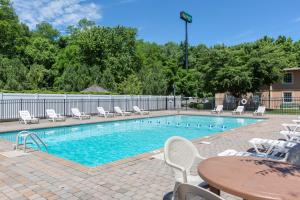 a swimming pool with white chairs and a table at Quality Inn Ledgewood - Dover in Ledgewood