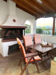 eine Terrasse mit Tisch und Stühlen sowie einem Kamin in der Unterkunft Aethera Maisonette in Kokóni