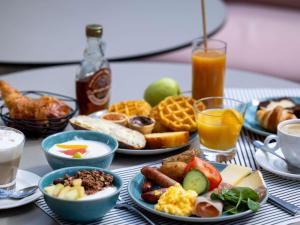 a table topped with plates of breakfast foods and drinks at Novotel Nice Centre Vieux Nice in Nice