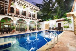 a house with a swimming pool in front of a house at Hotel boutique CM in La Vega