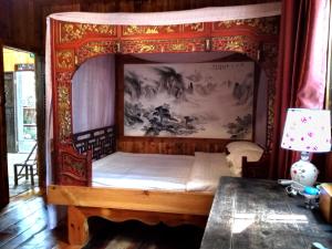 a bedroom with a canopy bed in a room at Old Street Xi'an Inn (Free Pick up Service) in Huangshan