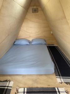 a bed in a tent with two pillows at Camping & Glamping For All in Itaúnas